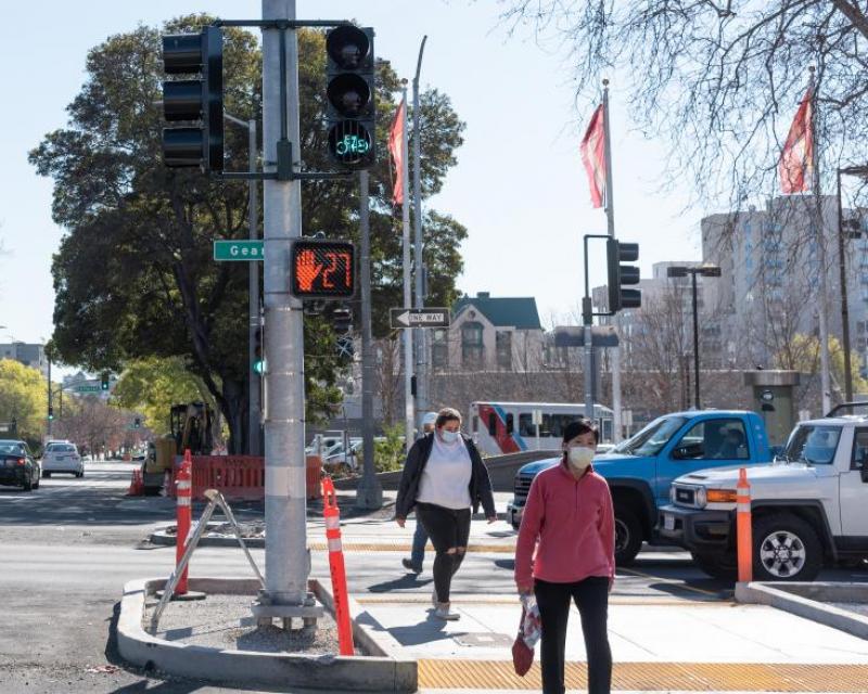 Image shows pedestrians walking across Geary Boulevard